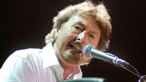 Getty Images Rick Davies in a white shirt, singing into a microphone on stage at the O2 Arena, London, on October 6, 2010